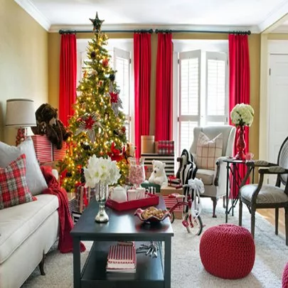Christmas decorated living room with tree, presents, and red accents.