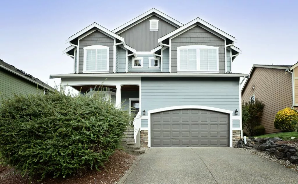 A two-story suburban house with light blue siding and gray accents